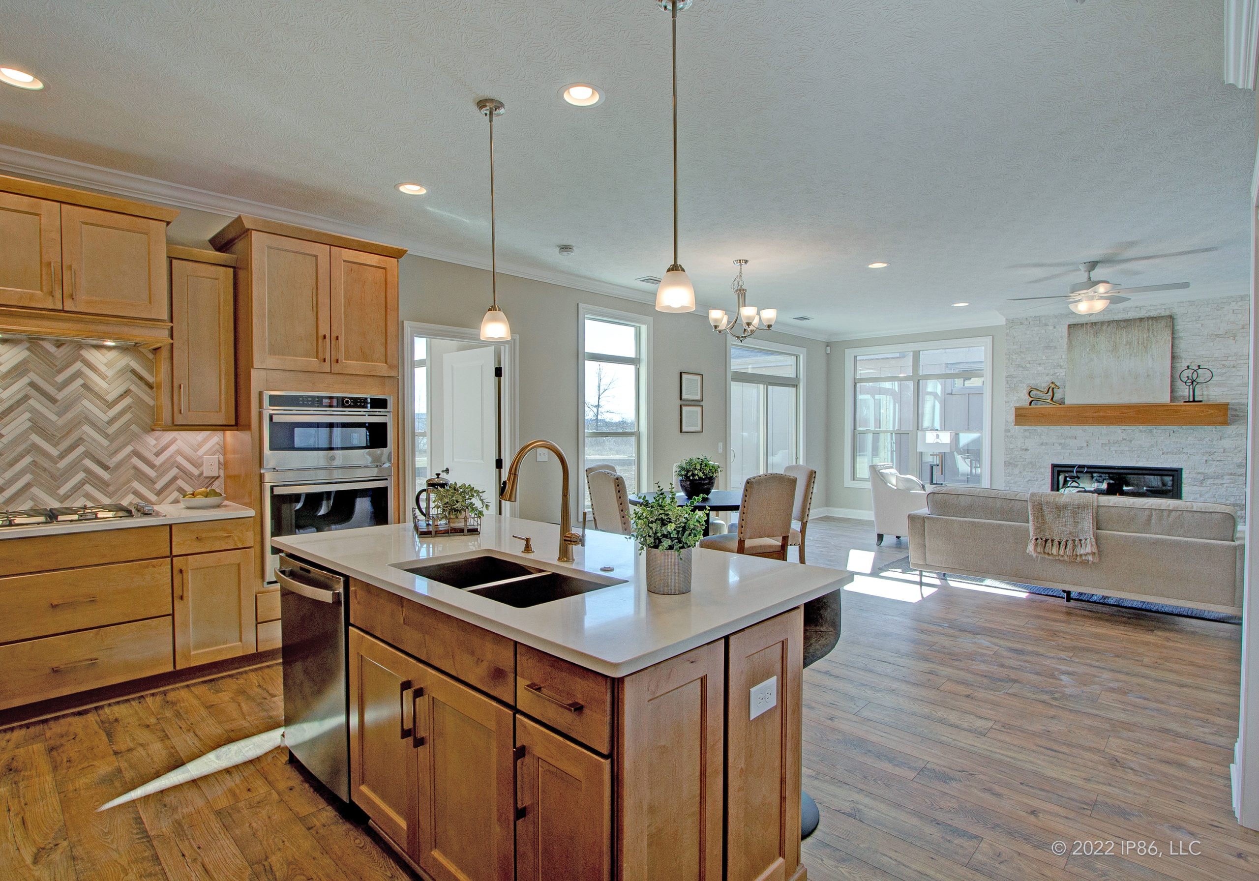 Elegant kitchen with wooden cabinetry and a central island, showcasing the design of The Capri model home.