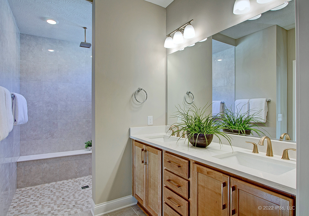 A modern bathroom featuring a sleek shower and a stylish sink, designed for The Capri model home.