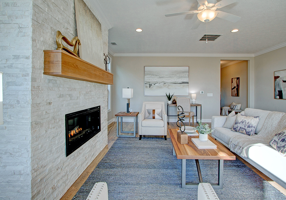 Elegant living room showcasing a fireplace and a comfortable couch, part of The Capri model home design.