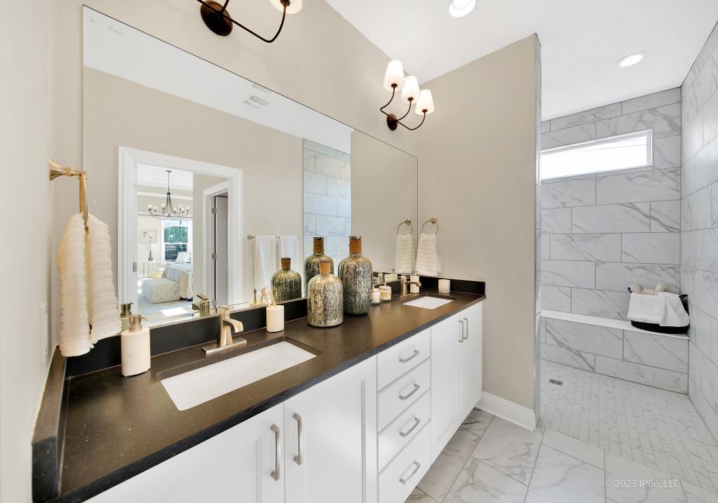 A luxurious bathroom featuring marble countertops and a double sink, designed as the Portico model by New Leaf Homes.