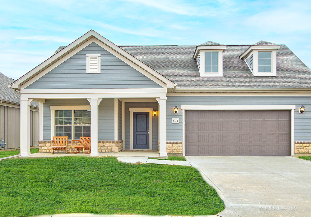 A house model, Promenade by New Leaf Homes, featuring a garage and a well-maintained front yard.