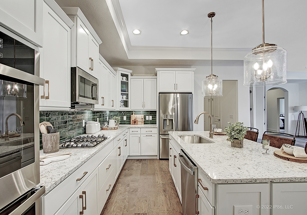 A modern kitchen featuring a center island and stainless steel appliances, designed as the Promenade model by New Leaf Homes.