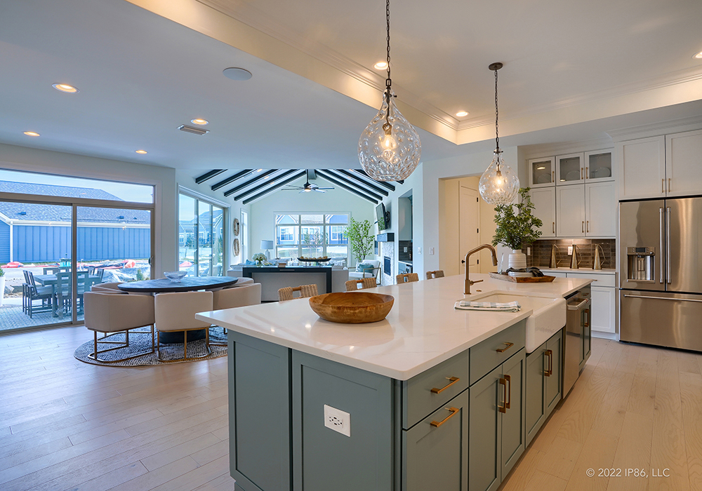 A modern kitchen featuring a center island and dining area, designed as the Provenance model by New Leaf Homes.