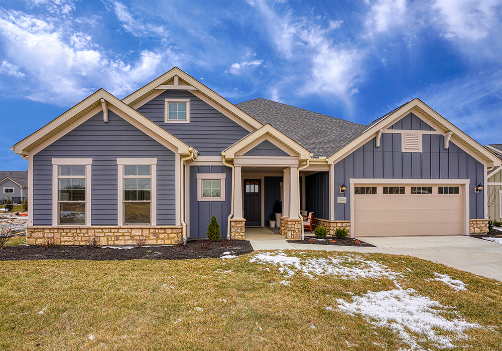 A blue house with a garage, named Provenance, designed by New Leaf Homes, showcasing modern architecture.