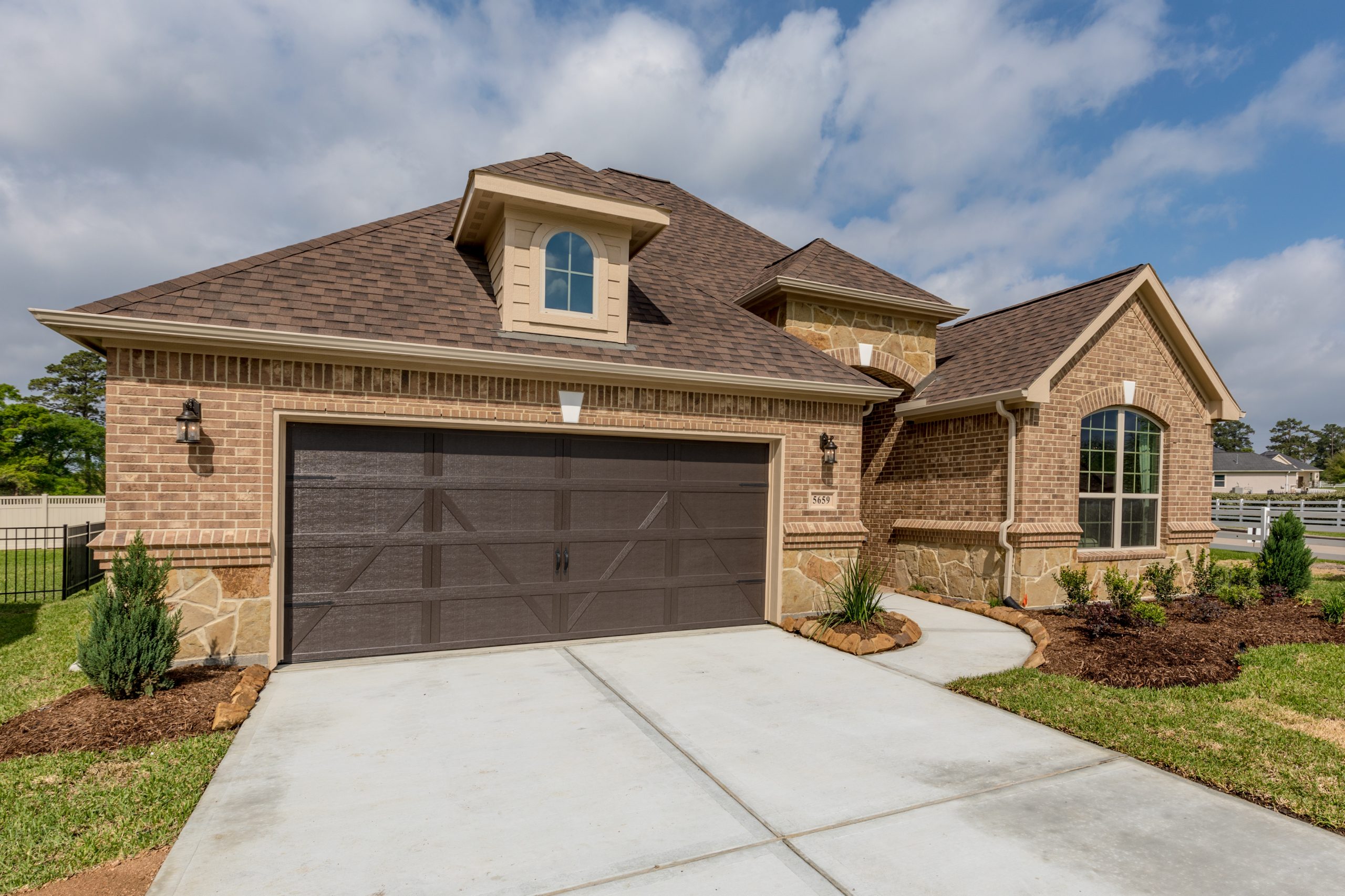 A Torino model home by New Leaf Homes featuring a spacious garage and driveway.