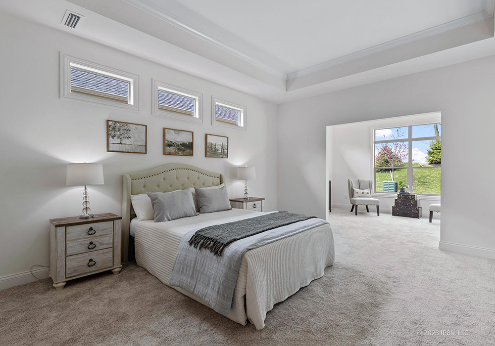 A serene bedroom featuring white walls and carpeting, showcasing the Verona model by New Leaf Homes.