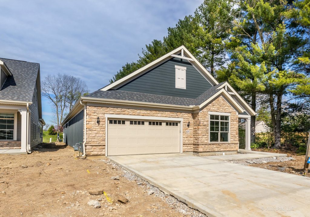 A Verona model home by New Leaf Homes featuring two garages and a spacious driveway.