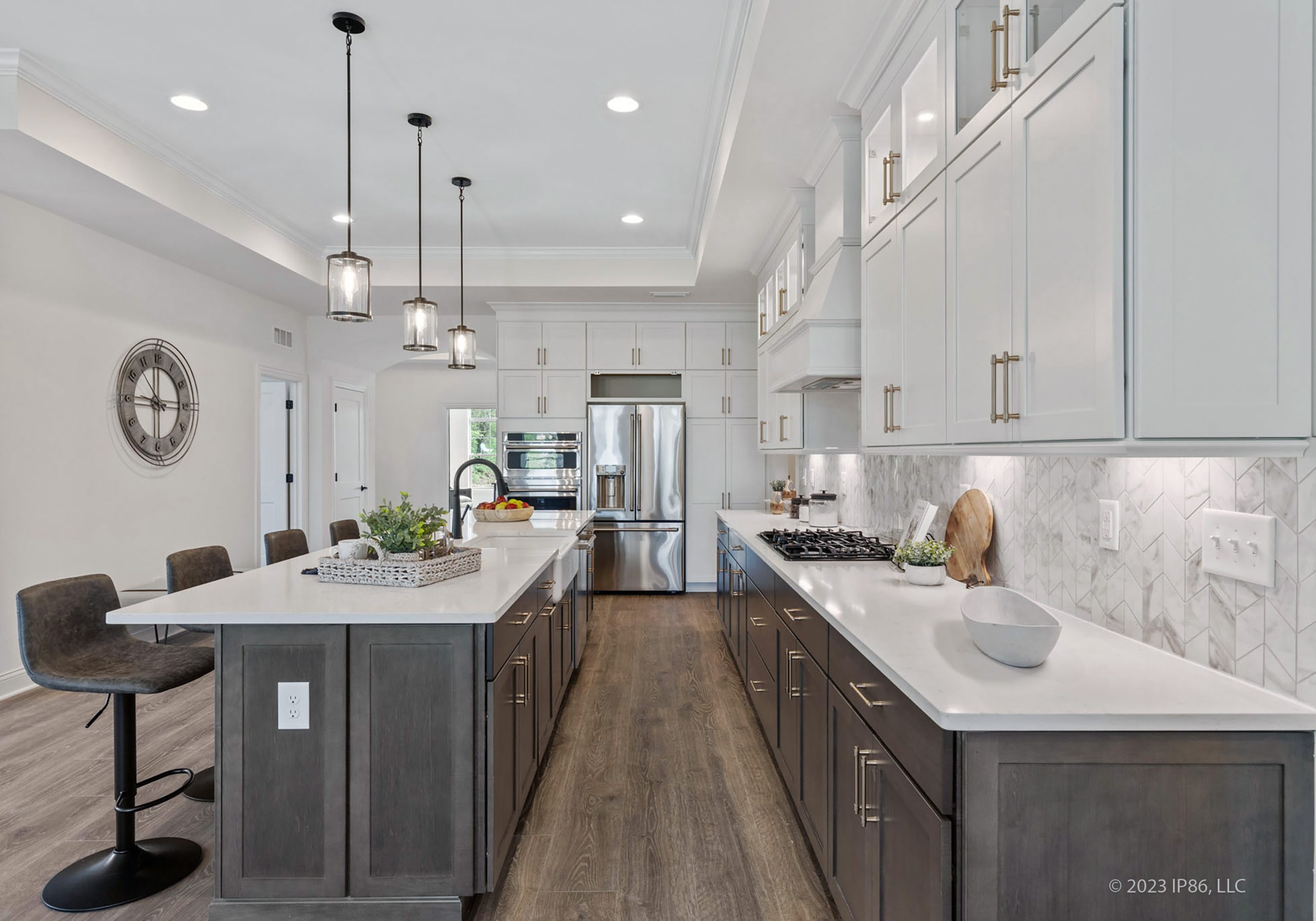 A modern kitchen featuring white cabinets and gray countertops, designed as the Verona model by New Leaf Homes.