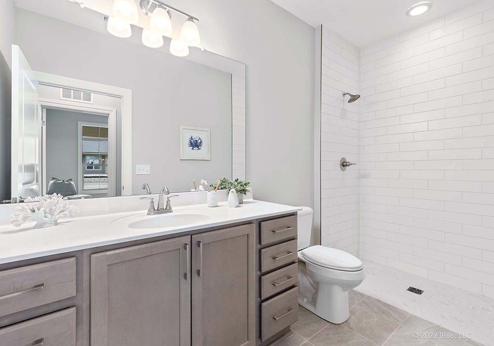 A modern bathroom featuring a Torino model by New Leaf Homes, equipped with a shower, toilet, and sink.