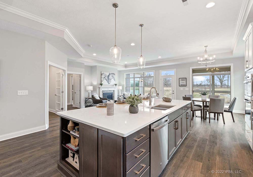 A Torino kitchen by New Leaf Homes featuring a center island and elegant hardwood floors.