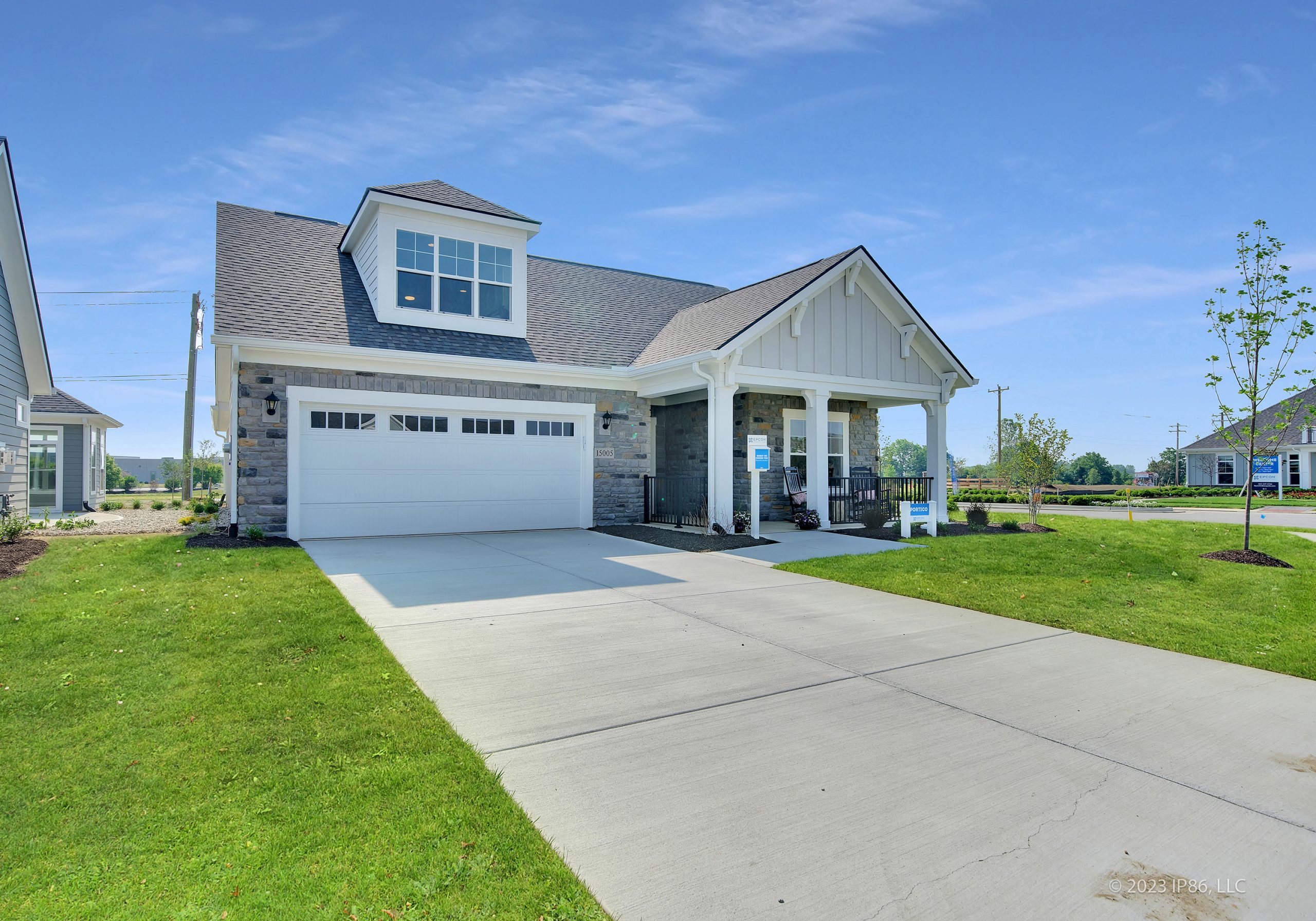 A well-maintained home showcasing a driveway and garage, complemented by landscaping and a bright, clear atmosphere