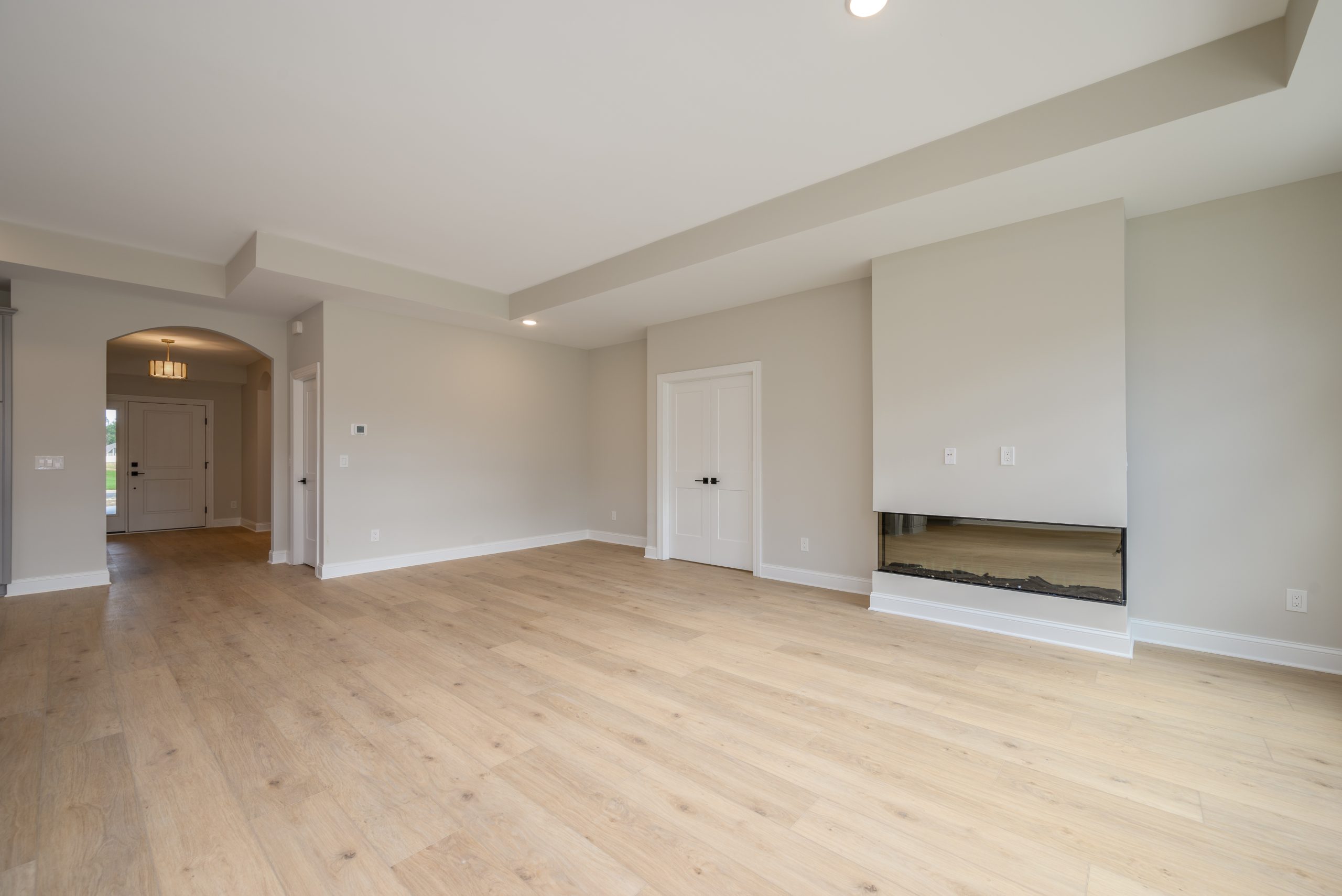 Living room of the move-in ready home at 3348 Willow Lane, featuring gray Torino furniture by New Leaf Homes, complemented by a cozy fireplace.